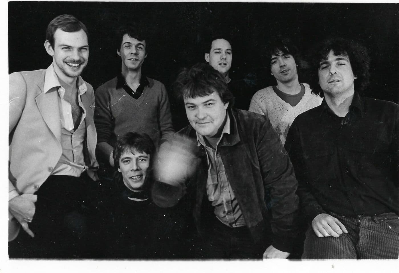 Zwart-witfoto van de oprichters van de Mazzo: zeven jonge mannen dicht bij elkaar, lachend naar de camera