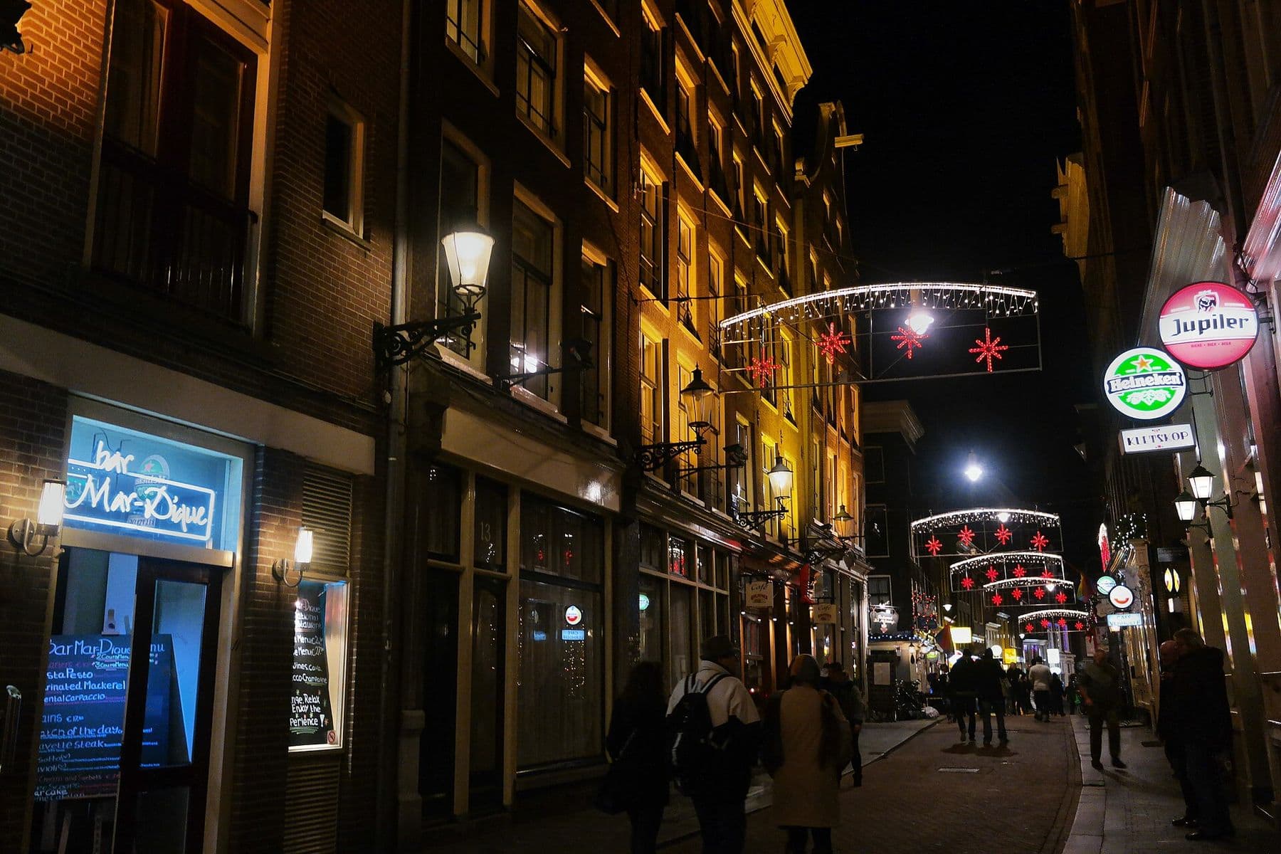 De Zeedijk bij avond met kerstverlichting boven de straat